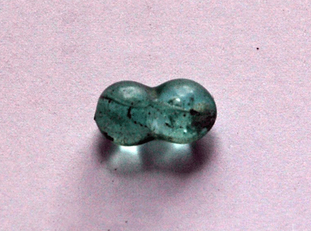 Photograph of a dumbbell shaped blue glass bead