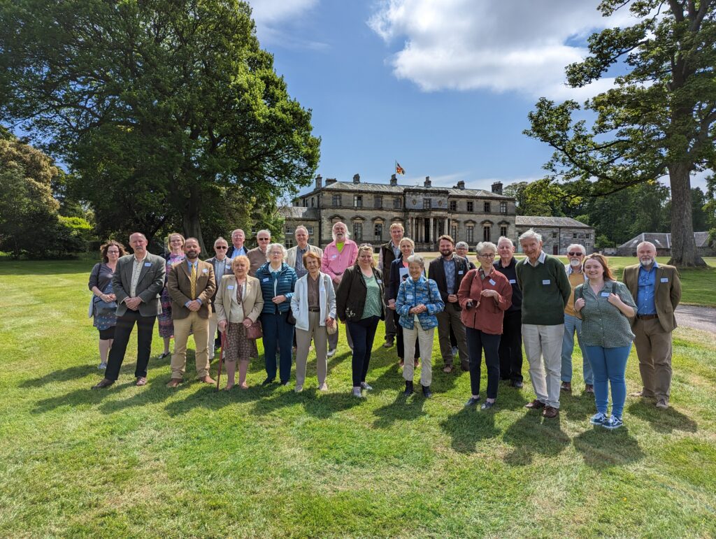 Group of people standing in front of a historic building smiling