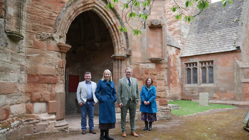 Group of people standing in front of an old church