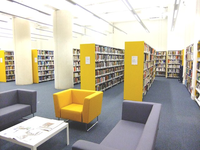 Photo of a library interior with couches and stacks of books