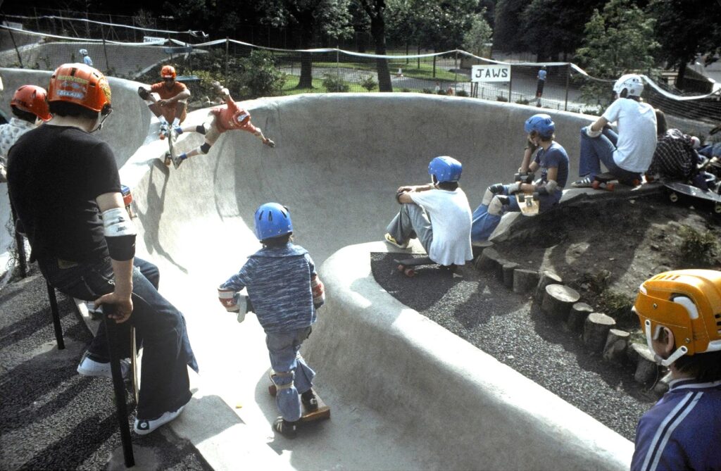 Young people in 1978 wearing helmets and other safety gear skateboarding at Kelvin Wheelies skatepark