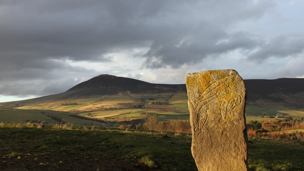 Craw Stane with Tap o' Noth (Credit: Cathy MacIver) Carved stone in front of a mountain landscape