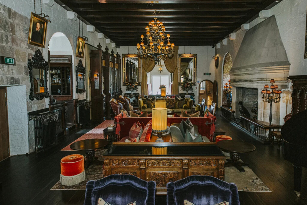 A characterful interior space within Borthwick Castle, combining historic features with rich textures, statement lighting, and comfortable seating.
