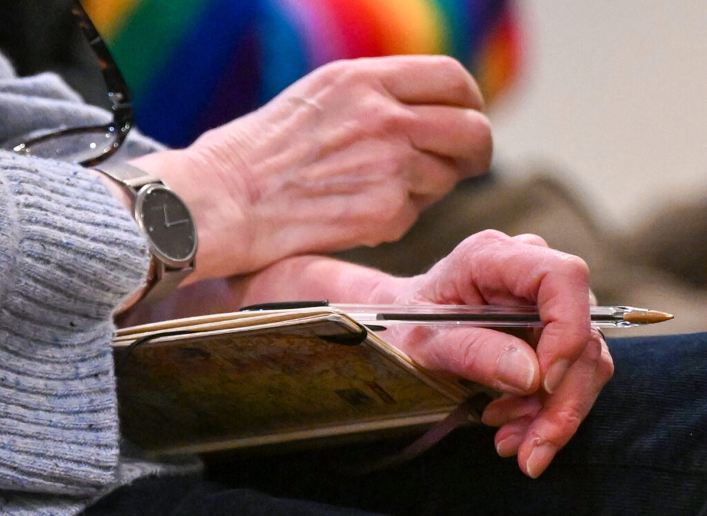 Person's hands holding notebook and pen